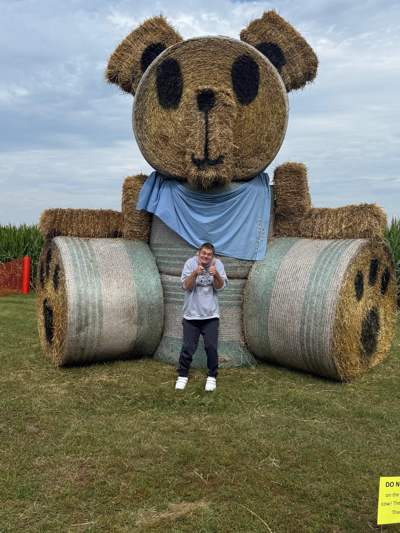 A resident in front of the giant hay-bale bear at the annual corn maze