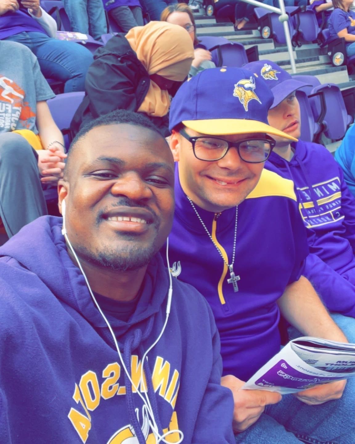 Calvin, founder of Aziza's Residential Care, at a Vikings game with a resident